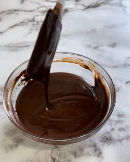 Una ciotola di salsa al cioccolato con un cucchiaio dentro