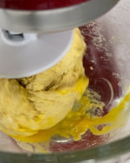 Primo piano di un'impastatrice con una palla di impasto al suo interno.