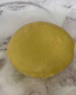 Un limone giallo è appoggiato su una superficie di marmo.