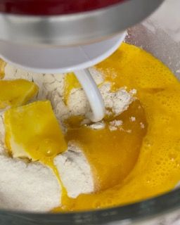 Un mixer mescola uova e farina in una ciotola.