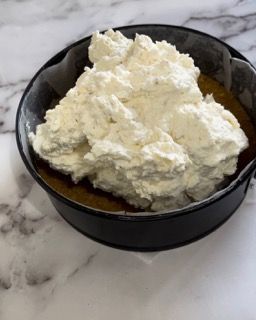 Una ciotola di panna montata è appoggiata su un tavolo.