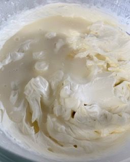 Primo piano di una ciotola di panna montata su un tavolo.