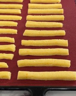 Un mazzo di bastoncini gialli è allineato su un tappetino rosso.