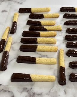 Una fila di biscotti ricoperti di cioccolato su una superficie di marmo