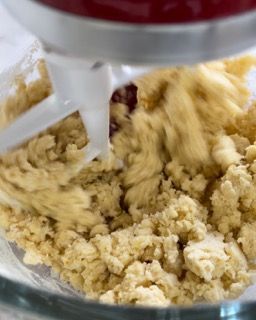 Un mixer sta mescolando un impasto in una ciotola di vetro.