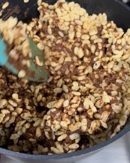 Una padella piena di riso e cioccolato mescolati con una spatola.