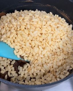 Una padella piena di riso e una spatola blu