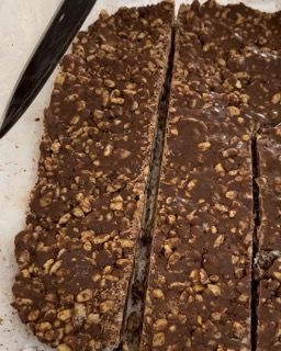 Un primo piano di una barretta di cioccolato con sopra delle noci