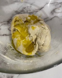 Primo piano di una palla di pasta in una ciotola di vetro.