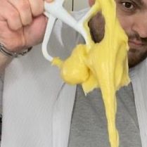 Un uomo tiene in mano un paio di forbici da cui esce una melma gialla.