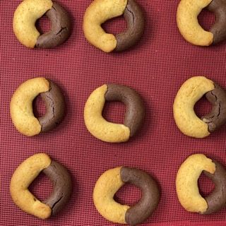 Un mucchio di ciambelle sono sedute su un panno rosso