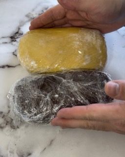 Una persona tiene in mano due tipi diversi di impasto.