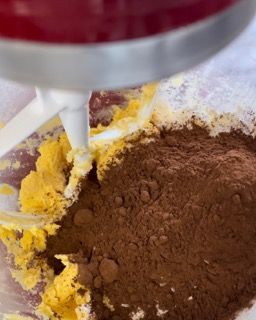 Un mixer mescola le uova e il cacao in polvere in una ciotola.