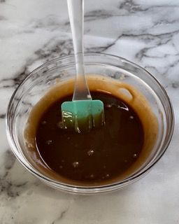 Una ciotola di salsa bruna con una spatola dentro.