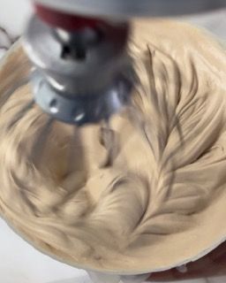 Una persona sta mescolando una sostanza cremosa in un mixer.