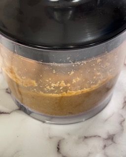 Primo piano di una ciotola di burro di arachidi su un tavolo.