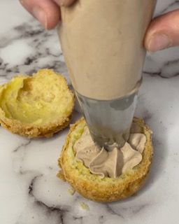 Una persona sta glassando un dolce con una sac à poche.