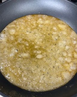 Una pentola piena di un liquido giallo sta cuocendo sul fornello.