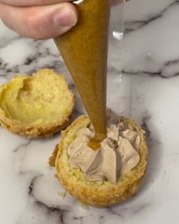 Una persona sta versando la glassa in un dolce con una sac à poche.