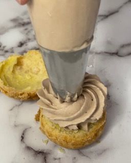 Una persona sta glassando una torta con una sac à poche.