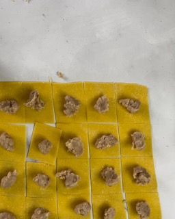 Un mucchio di quadrati gialli con sopra della carne su un tavolo.