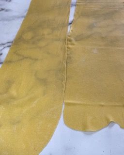 Due pezzi di pasta sono appoggiati uno sopra l'altro su un tavolo.