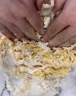 Una persona sta impastando un impasto con le mani.