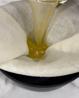 Primo piano di una persona che versa del liquido in un tovagliolo di carta.