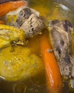 Pollo e carote vengono cotti in una pentola di brodo.
