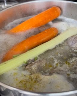 Carote e sedano vengono cotti in una pentola d'acqua