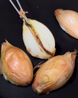 Un mazzo di cipolle è appoggiato su una superficie nera