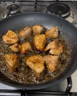 Il pollo viene cucinato in una padella sul fornello