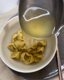 Una ciotola di pasta viene versata con un mestolo