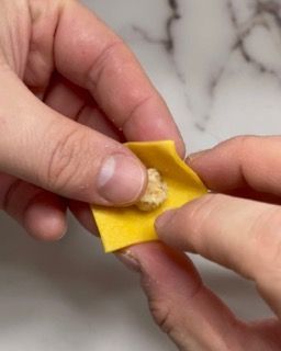 Una persona tiene in mano un pezzo di formaggio.