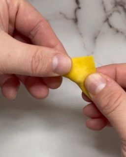 Una persona tiene in mano un pezzo di stoffa gialla.