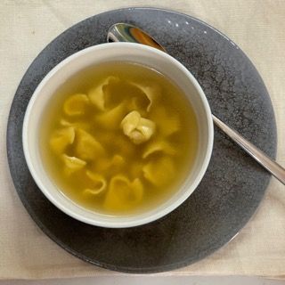 Una ciotola di zuppa su un piatto con un cucchiaio