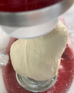 Una palla di pasta viene impastata in un'impastatrice.