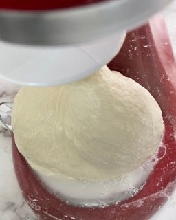 Una palla di pasta viene impastata in un'impastatrice.