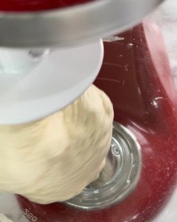 Un primo piano di un mixer con una palla di pasta dentro