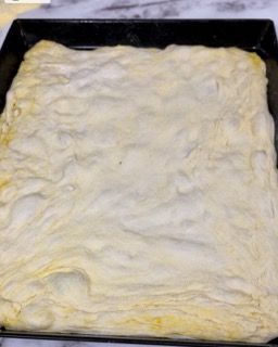 Un vassoio di pasta per pizza è appoggiato su un tavolo.