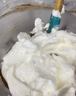 Una ciotola di panna montata con una spatola dentro.