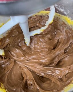 Una ciotola di glassa al cioccolato con una spatola dentro