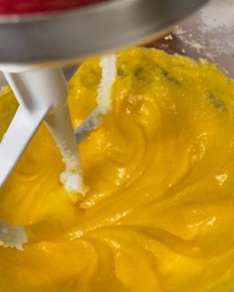 Un mixer sta mescolando un liquido giallo in una ciotola.