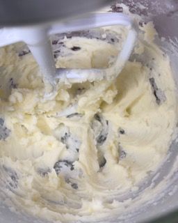 Un mixer sta mescolando il burro in una ciotola con una spatola.