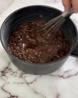 Una persona sta mescolando una ciotola di salsa al cioccolato.