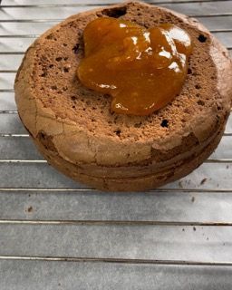 Una torta al cioccolato con marmellata sopra su una griglia di raffreddamento