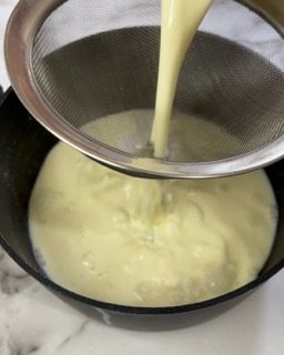 Si versa la salsa in una padella attraverso un colino.