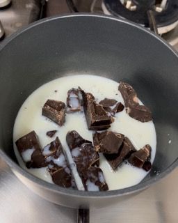 Una pentola piena di latte e cioccolato su un fornello