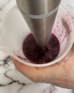 Una persona versa un liquido in un misurino.