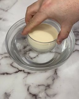 Una persona tiene in mano una piccola ciotola di liquido.